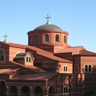 A large red brick church with a cross on top.