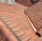 A roof with a red tile on it.