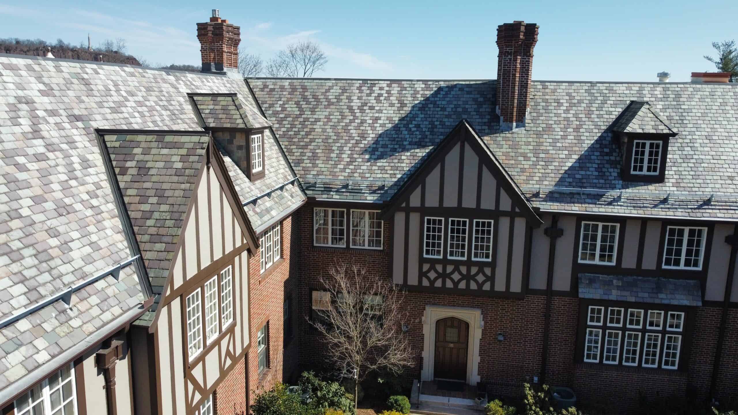 an aerial view of a brick house with a slate roof.