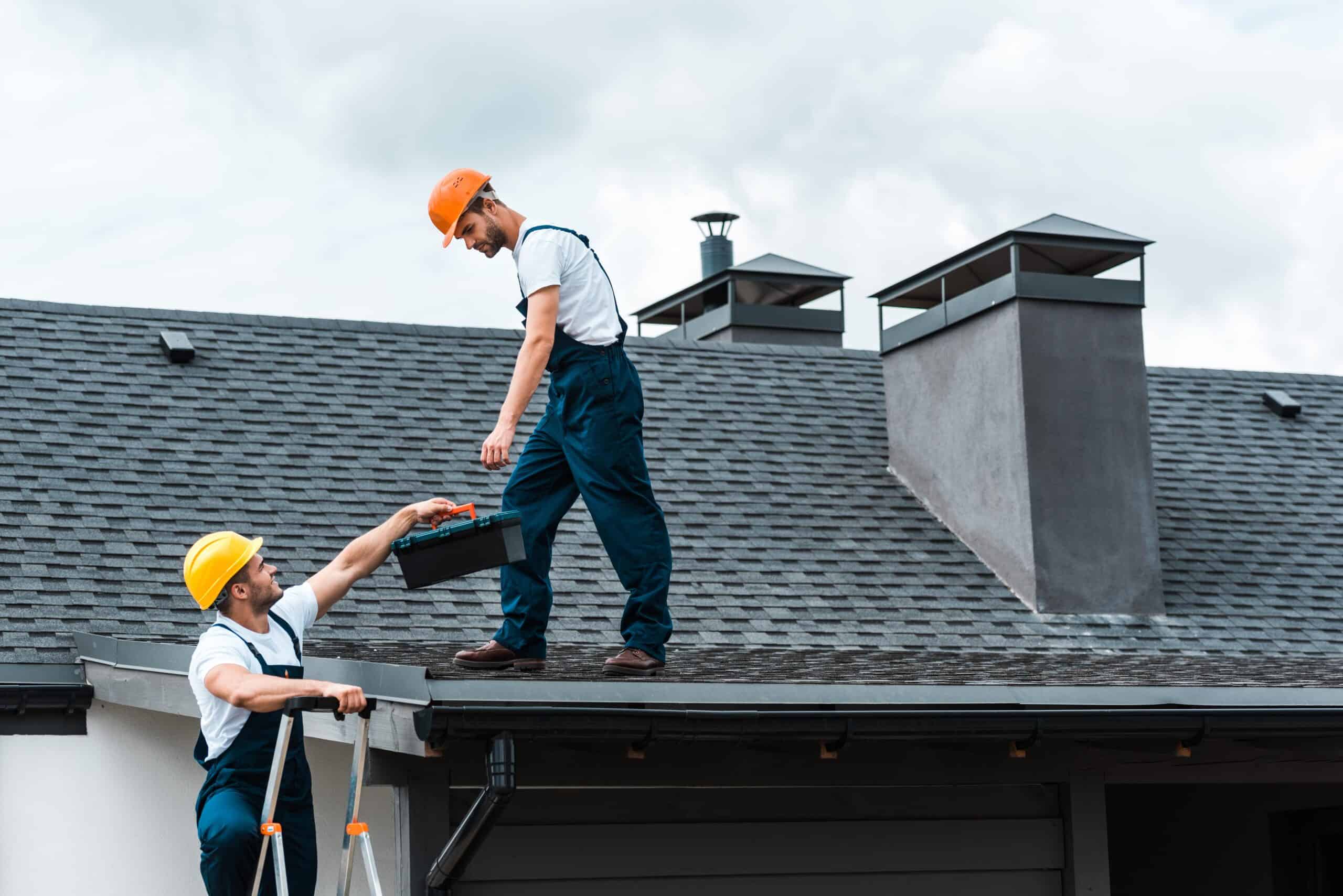 two men working on the roof of a house.
