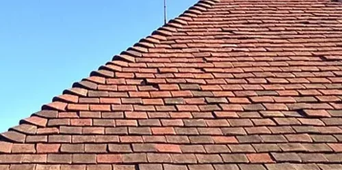 a red tiled roof with a blue sky.