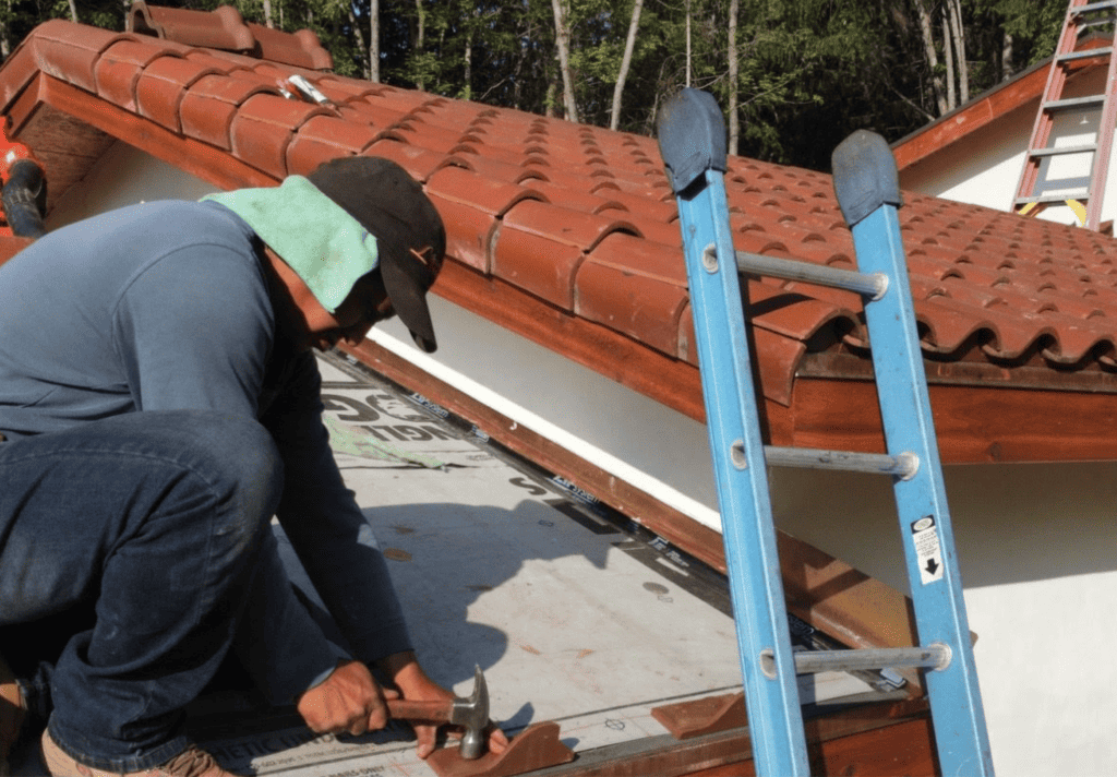 a man working on a roof with a ladder.